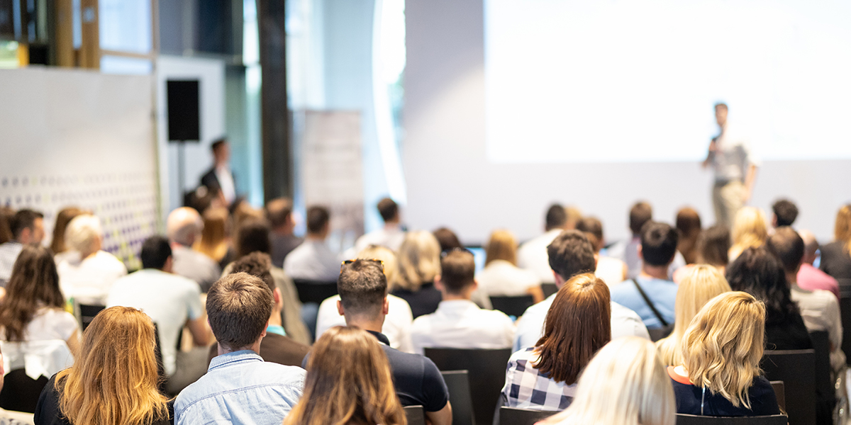 Speaker and audience at a conference