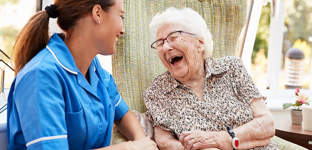 Nurse laughing with elderly lady