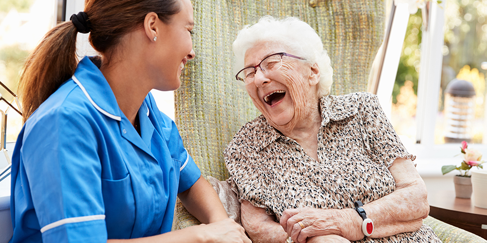 Nurse laughing with elderly lady