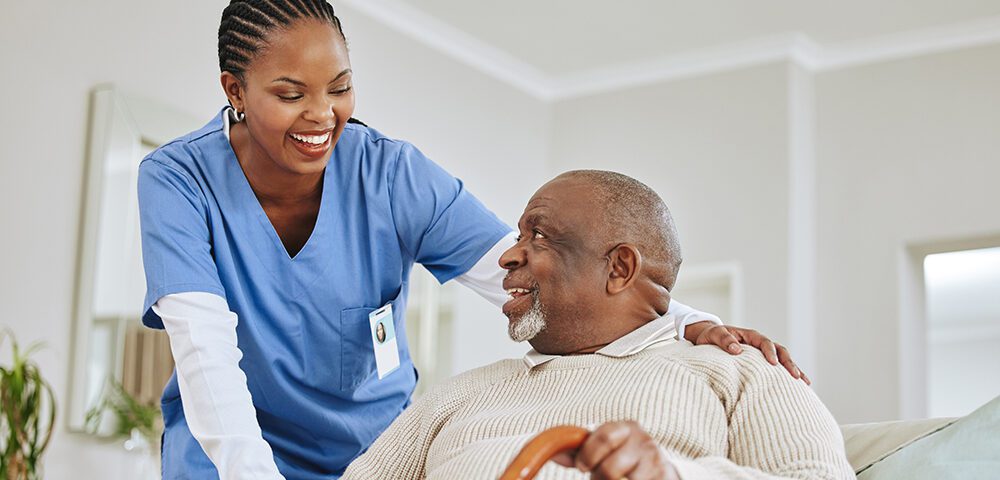 Nurse in scrubs with elderly man in wheelchair