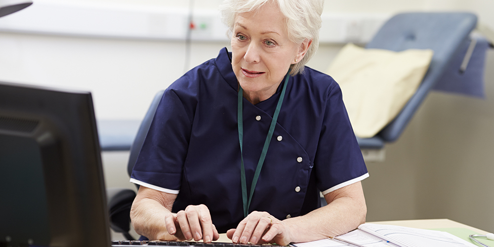 Nurse entering data into a computer